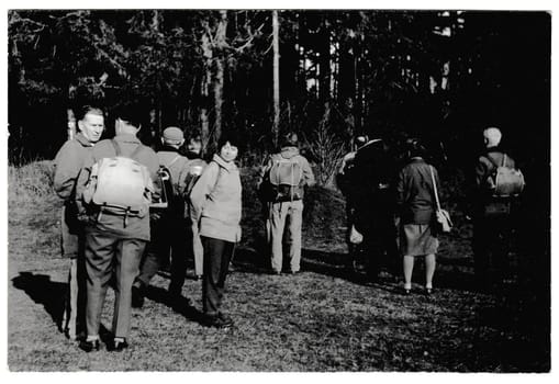 MILICIN, THE CZECHOSLOVAK SOCIALIST REPUBLIC - MARCH 19, 1972: Retro photo shows tourists go for a walk. Black and white vintage photography.