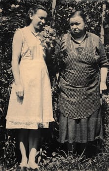 THE CZECHOSLOVAK SOCIALIST REPUBLIC - CIRCA 1960s: Retro photo shows two women stand in the garden. Black and white vintage photography