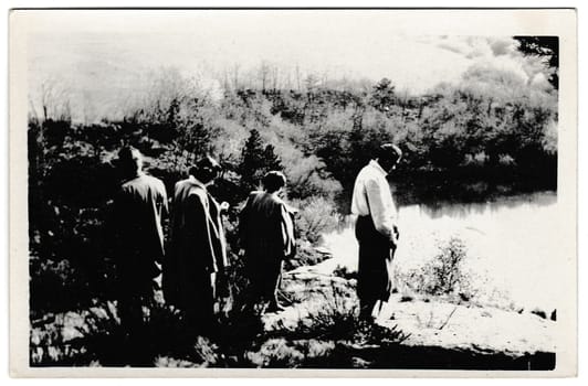 THE CZECHOSLOVAK SOCIALIST REPUBLIC - MAY 9, 1954: Retro photo shows tourists stand on the bank of the pond. Black and white vintage photography