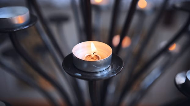 Candlestick holder with burning candles in a Catholic church