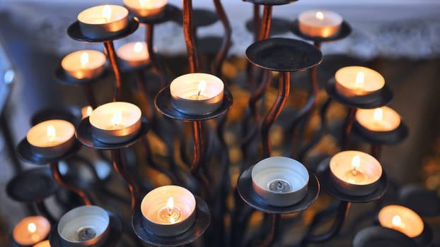 Candlestick holder with burning candles in a Catholic church