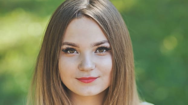 Portrait of a young girl in a park. Close-up of her face
