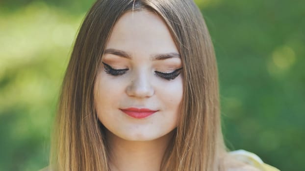 Portrait of a young girl in a park. Close-up of her face