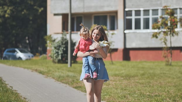 A young mother walks with her daughter through town