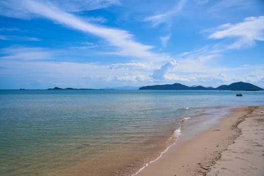 View from the sandy beach to the silhouettes of islands in the sea. Beautiful beach of Thailand.