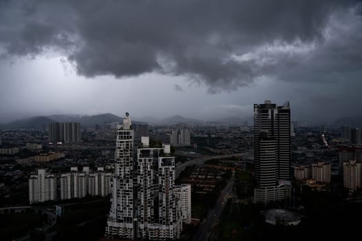 A black storm cloud of rain over the town. Bad weather conditions. Kuala Lumpur, Malaysia - 11.11.2022