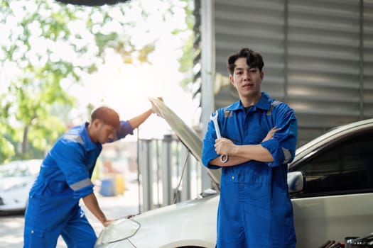 portrait of positive asian auto mechanic in uniform posing after work, he is keen on repairing cars, automobiles.