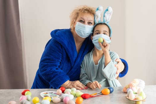 grandmother and granddaughter at home on quarantine with medical mask. Coronavirus, illness, infection, flue, surgical bandage