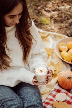 Portrait of a girl having picnic outdoors, enjoying autumn nature, having good time