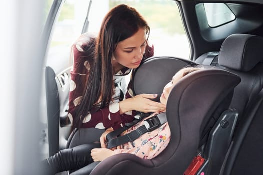 Mother with her daughter inside of modern automobile together.