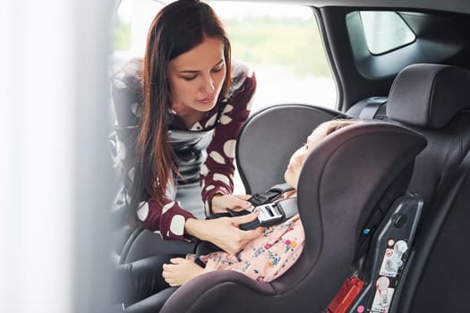 Mother with her daughter inside of modern automobile together.