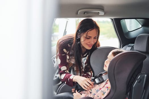Mother with her daughter inside of modern automobile together.