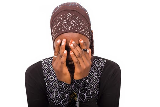 young muslim isolated woman sitting on white background praying.