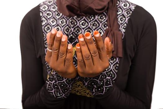 young muslim woman sitting on a mat praying.