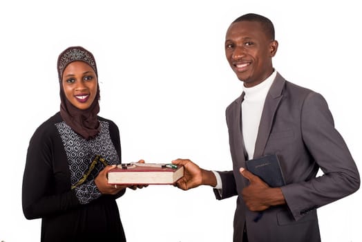 portraits of two smiling religious people holding a book on white background and looking at the camera