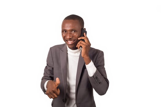 portrait of young smiling man in suit standing phoning isolated on white background.