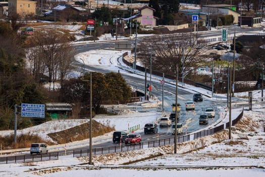 Sekigahara, Japan - December 25, 2022: Light traffic on curved road through small town in snow. High quality photo