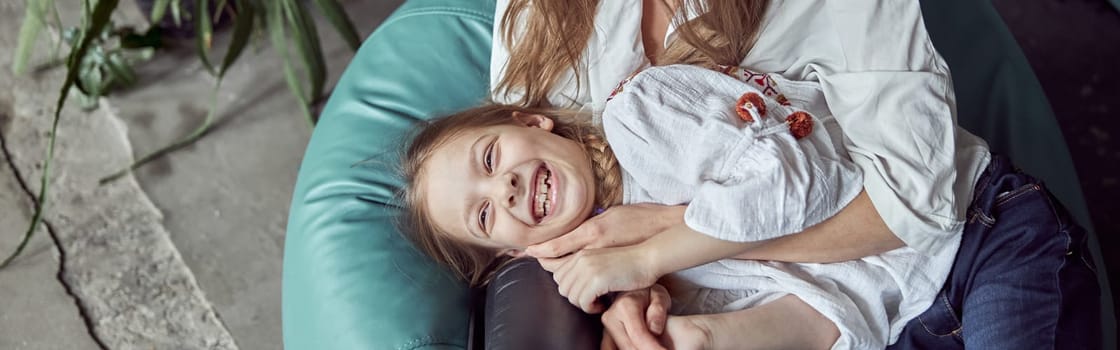 Happy caucasian mother with young beautiful cheerful daughter are having time together