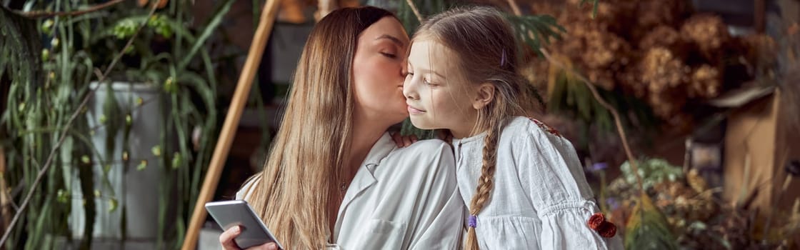 Happy caucasian mother with young beautiful cheerful daughter are having time together