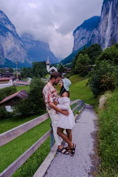 men and women visiting Lauterbrunnen valley with a gorgeous waterfall and Swiss Alps in the background, Berner Oberland, Switzerland, Europe during summer