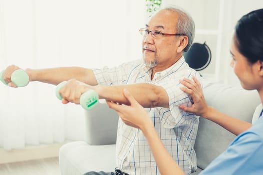 Contented senior patient doing physical therapy with the help of his caregiver. Senior physical therapy, physiotherapy treatment, nursing home for the elderly