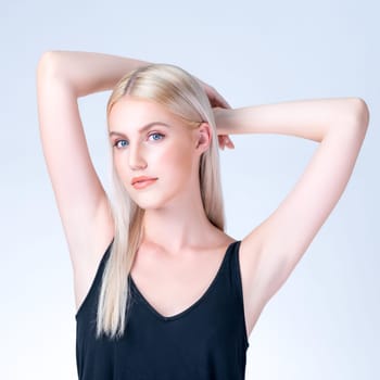 Personable woman lifting her armpit showing hairless hygiene underarm as beauty posing for cleanliness and perfect smooth skincare treatment in isolated background. Hair removal and epilation concept.