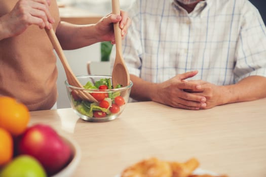 Contented senior couples who are happy to cook together with bread veggies and fruit in their kitchen.