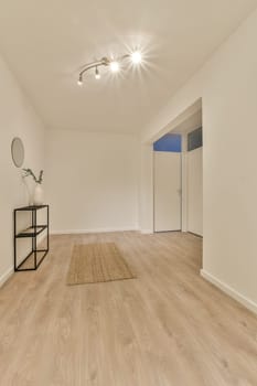 an empty room with wood flooring and white walls on the wall, there is a mirror in the corner