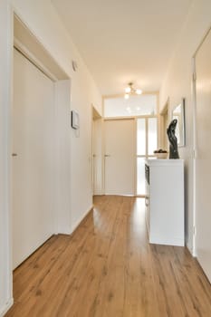 an empty living room with wood flooring and white trim on the walls, door to the hallway leading into another room