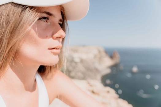 Woman travel sea. Young Happy woman in a long red dress posing on a beach near the sea on background of volcanic rocks, like in Iceland, sharing travel adventure journey