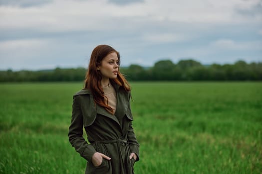 portrait of a beautiful, red-haired woman standing in a field in spring. Rainy weather, unity with nature. High quality photo