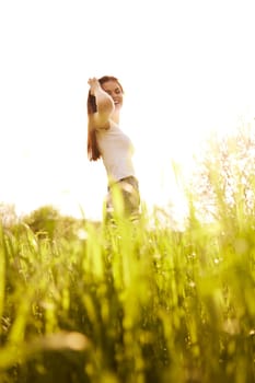 a woman on a bright sunny summer day standing in a yellow field. High quality photo
