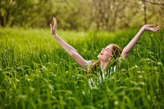 a woman rejoices in a summer day and raises her hands enthusiastically. High quality photo