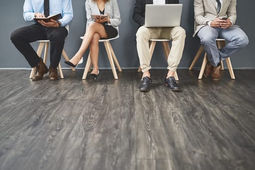 Getting ready to put their best foot forward. a group of unrecognisable businesspeople waiting in line for a job interview