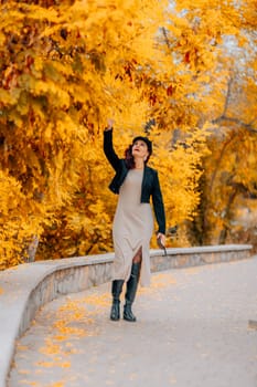 A woman walks outdoors in autumn, enjoys the autumn weather