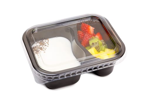 Portion of yogurt dessert with strawberry and kiwi and pineapple in a plastic bowl with a lid. High quality photo
