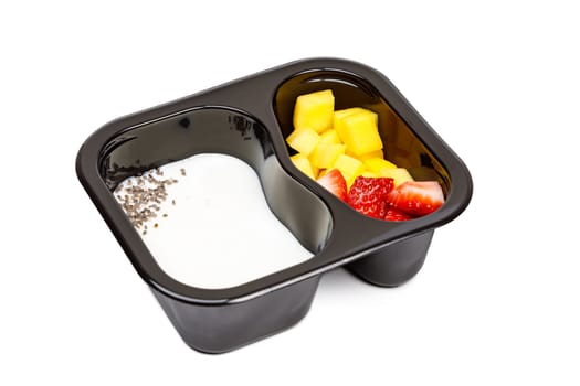 Portion of yogurt dessert with strawberry and mango in a plastic bowl. High quality photo