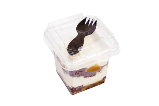 Portion of chocolate caramel mousse in a plastic cup with a fork on the lid on a white background. High quality photo