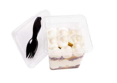Portion of chocolate caramel mousse in a plastic cup with a fork on the lid on a white background. High quality photo