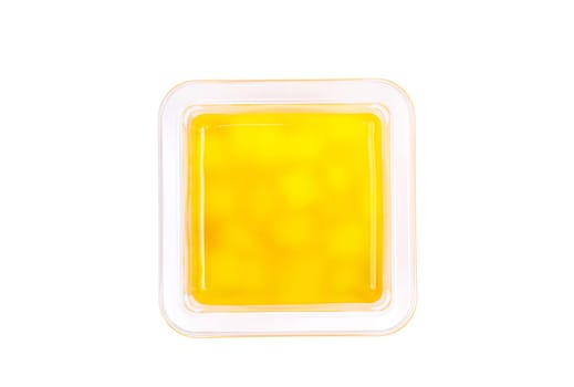 Grapefruit, mango and raspberry jelly in a plastic cup on a white background. View from above. High quality photo
