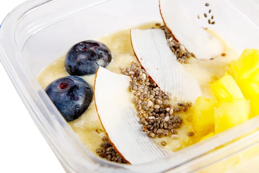 Smoothies with fresh fruits and nuts. Pineapple puree, banana. Pieces of coconut with blueberries. Close-up. High quality photo