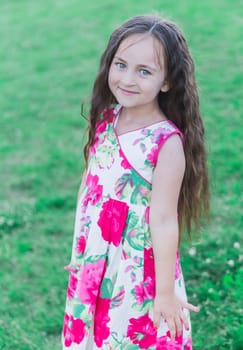 Pretty Girl in a colorful dress in the field.