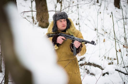Soviet soldier in the winter forest. Retro photo.