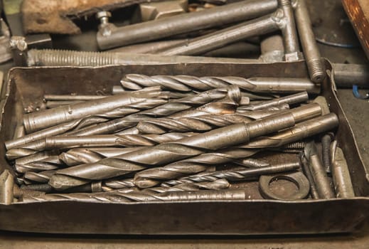 Old drills in a metal box at the factory.