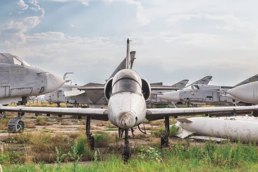 Old jet plane stands at an abandoned airfield.