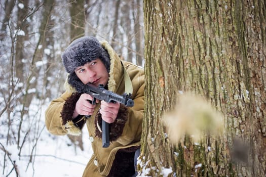 Soviet soldier in the winter forest. Retro photo.