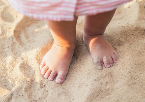 little baby feet of a child who walks along the seashore.