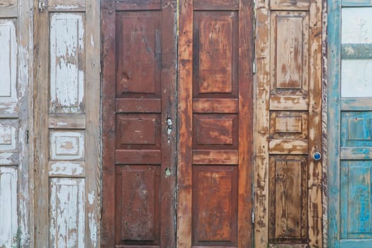 fence made of old doors with peeling paint.