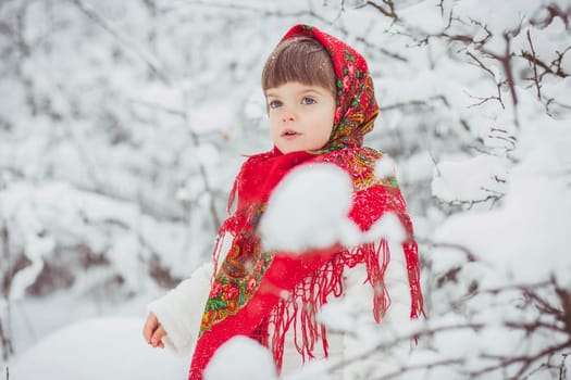 Beautiful little girl in old Ukrainian clothes in a winter forest.