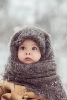 Retro photo of adorable baby in a woolen shawl in winter.